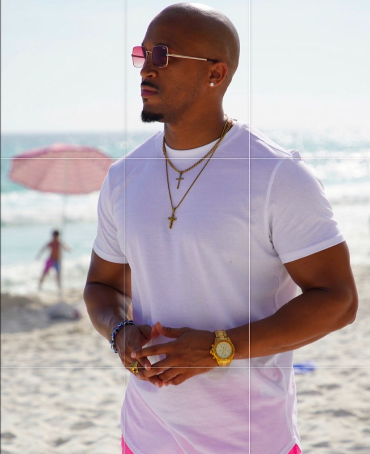 Marcus the Coach standing on the beach, calm and composed